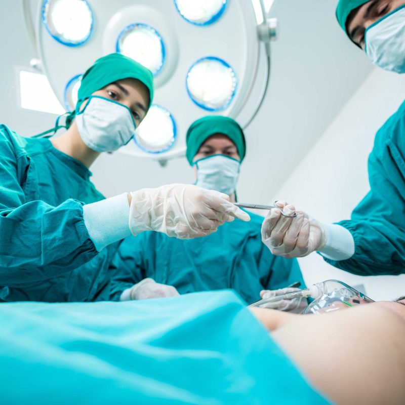 Surgeon Medical Team Performing Emergency Surgical Operation in Bright Modern Operating Room